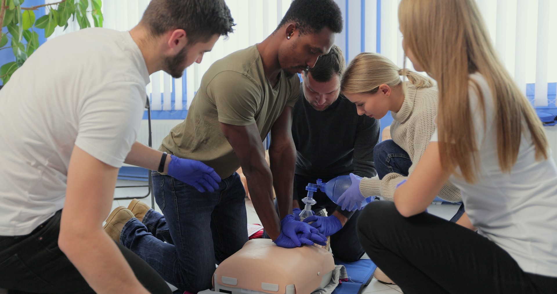 Closeup of students practicing CPR chest compression on dummy.